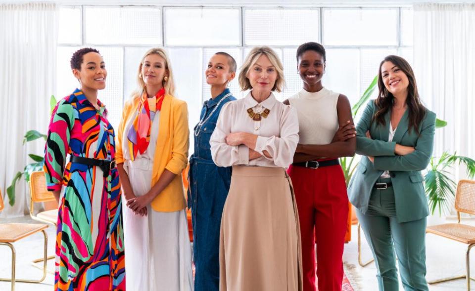 Colorfully dressed, multi-ethnic group of businesswomen pose for the camera.