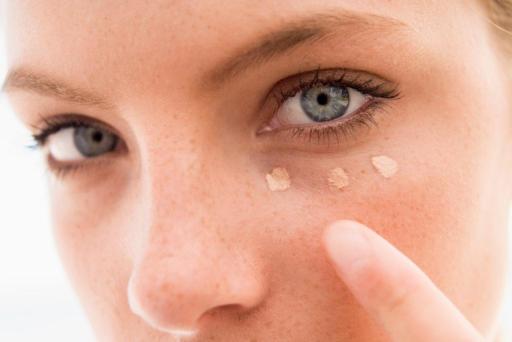 Woman putting concealer under her eye